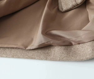 Detailed macro view of camel wool fabric and smooth dark brown satin lining of the jacket
