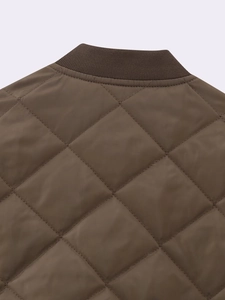 Close-up of diamond quilted pattern and ribbed knit collar on the brown puffer jacket