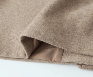 Close-up of beige tweed texture and smooth satin lining of the casual shirt jacket