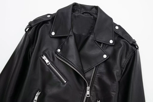 Detailed macro shot of faux leather texture, wide lapels and silver zippers on a jacket