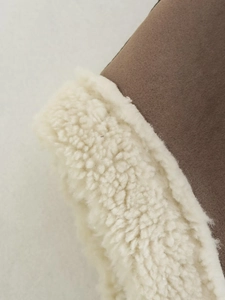 Detail of brown suede leather fabric and thick white faux shearling fur lining texture
