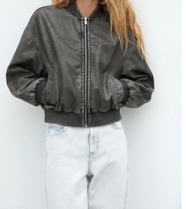 Détail de la texture cuir PU délavé de la veste bomber Y2K avec finitions en bords-côtes