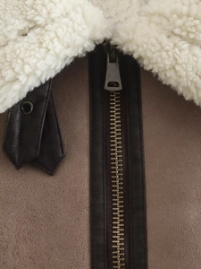 Detail of shearling collar and metal zipper on brown suede vintage jacket