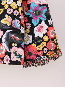 Detail of quilted floral jacket featuring vibrant patterns and ruffled hem texture