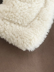 Close-up of white shearling texture and dark brown suede lining for a warm winter vest