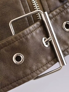 Macro detail of washed gradient faux leather jacket with metal buckles and fine stitching