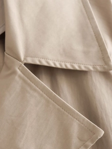 Macro shot of high-quality double-row stitching on beige cotton trench coat lapel