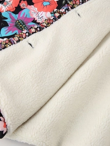Macro view of Y2K floral print outer fabric and soft white sherpa fleece lining detail