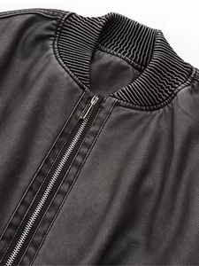 Détail du col en tricot côtelé et de la fermeture éclair en métal argenté sur veste en cuir