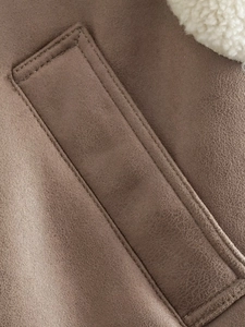 Close-up of brown faux suede fabric with white lamb wool lining and double stitching