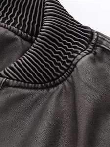 Détail macro du blouson bomber Y2K avec col côtelé et texture en cuir noir poli
