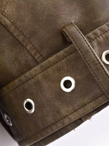 Macro shot of brown Y2K faux leather jacket texture with silver grommets and stitching