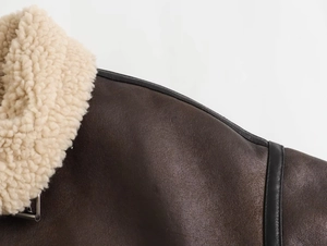 Detail of faux leather biker jacket with premium sheepskin fleece collar and metal buckles