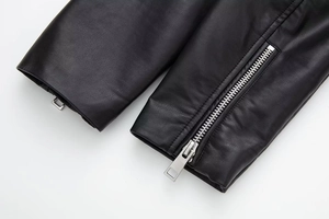 Close-up of black faux leather sleeve with silver metallic zipper detailing
