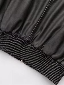 Détail de l'ourlet élastique côtelé et de la fermeture éclair en métal sur la veste Y2K
