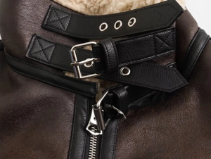 Detail of vintage faux leather aviator jacket with white shearling collar and metal buckle