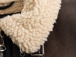 Detail of the thick sherpa fleece lining and textured brown leather on this Y2K moto jacket
