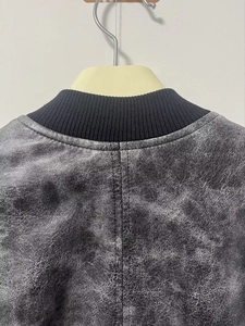 Detail view of vintage Y2K distressed black PU leather jacket with ribbed knit collar trim