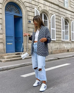 Outdoor shot of a navy geometric print puffer jacket and ripped jeans in a stylish outfit