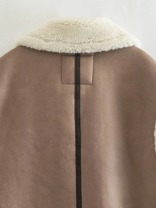 Close-up of brown faux suede vest featuring white shearling collar and leather back detail