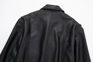 Close-up detail of back shoulder seams and action pleats on black faux leather jacket