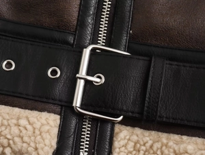 Detail of vintage PU leather jacket featuring thick faux shearling lining and metal belt buckle