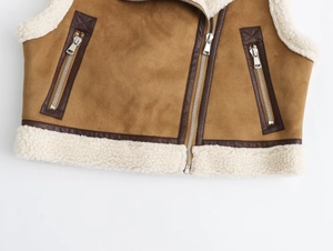 Détail du gilet en daim marron avec doublure en peau de mouton blanche et fermetures éclair