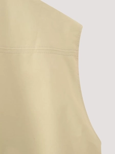 Macro detail of beige vest shoulder with double stitching and smooth fabric texture