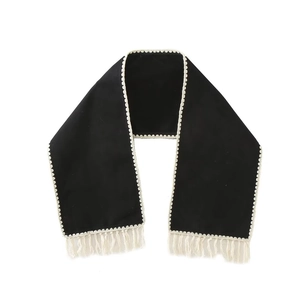 Detail of black wool shawl featuring white lace scalloped edges and short tassel trim
