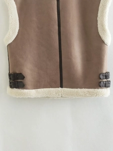 Detailed view of brown suede vest with white faux shearling lining and leather buckle straps