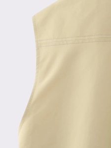 Detailed close-up showing reinforced double stitching on beige woven fabric vest