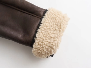 Detail of vintage Y2K jacket cuff featuring brown leather and white shearling lining