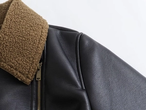 Détail du col en fourrure et du cuir noir texturé sur la veste Y2K pour femme