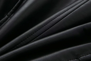Close-up of black faux leather jacket showing premium texture and double stitching detail