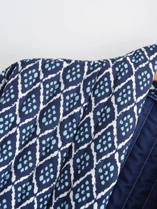 Detailed close-up of blue quilted fabric with white diamond patterns and light blue dots