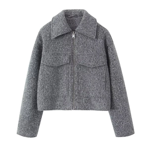 Close-up detail of dark grey cropped jacket with textured wool fabric and metal zipper