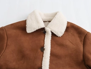 Close-up detail of brown faux suede jacket with white lamb wool collar and button textures