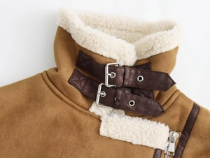 Détail du col montant coupe-vent avec boucles en cuir marron et fermeture éclair métallique