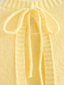 Detailed close-up of yellow Y2K knit vest showing waffle texture and delicate bow tie detail