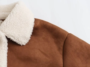 Detail of brown faux suede jacket featuring white faux shearling collar and shoulder seams