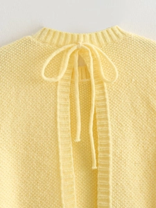 Y2K style light yellow knitted vest with tie-up bow detail and soft ribbed texture