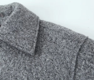 Detailed macro view of the grey tweed jacket texture and collar stitching craftsmanship