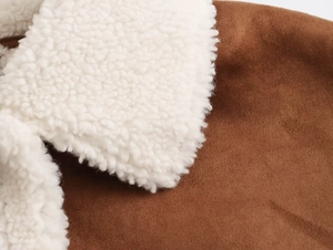Close-up of a warm brown suede jacket with soft white lamb wool fleece collar detail