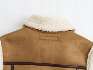 Détail du gilet en daim avec col en polaire et liseré décoratif en cuir marron foncé