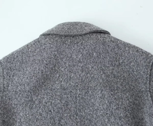 Detailed macro view of gray tweed jacket collar showing texture and stitching