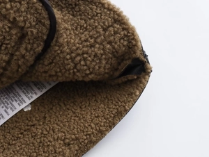 Détail de la doublure polaire de la veste avec étiquettes d'entretien et bordure noire