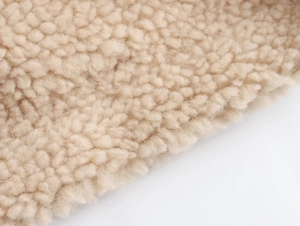 Nahaufnahme der weichen beigen Fleece-Struktur einer wendbaren Y2K Damen-Weste