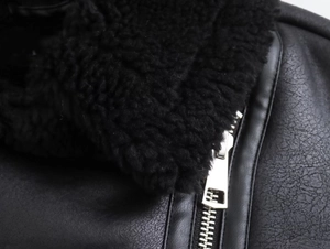 Dettaglio della trama in pelle nera e collo in pelliccia sintetica con zip in argento