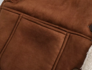 Detailed macro view of dark brown faux suede jacket fabric with soft white shearling lining