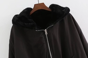 Close-up of black hooded flight jacket with plush faux fur lining and silver metal zipper